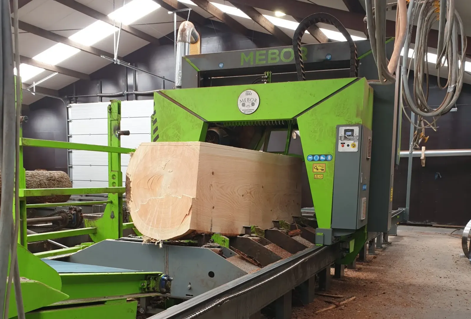 Lintzaagmachine in de zagerij van CenWood die een eiken stam op maat zaagt